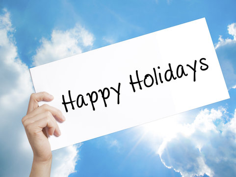 Happy Holidays Sign on white paper. Man Hand Holding Paper with text. Isolated on sky background