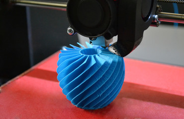 3D printer working and creating an object from the hot molten plastic close-up. Automatic three dimensional 3d printer performs plastic blue colors modeling in laboratory.