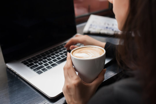 Rear view of a creative female freelancer sitting front laptop