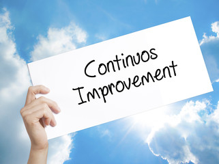 Continuos Improvement Sign on white paper. Man Hand Holding Paper with text. Isolated on sky background
