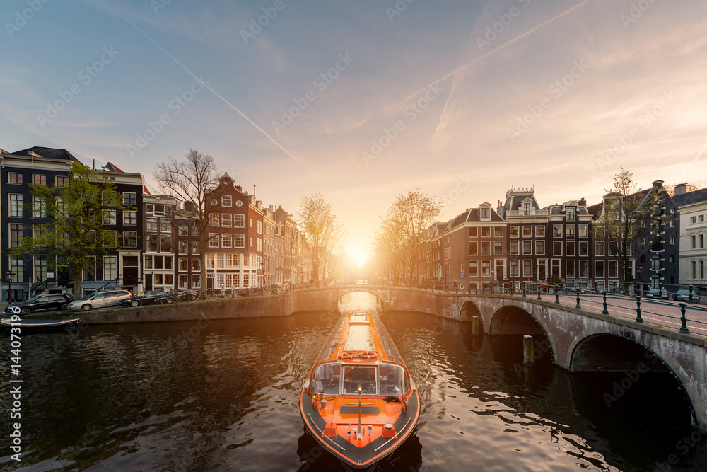 Obraz na płótnie Amsterdam canal cruise ship with Netherlands traditional house in Amsterdam, Netherlands. w salonie