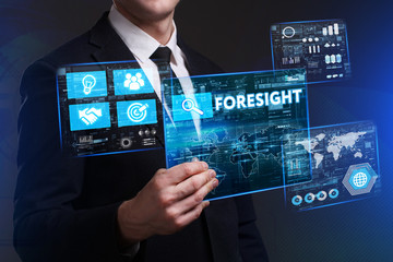 Business, Technology, Internet and network concept. Young businessman working on a virtual screen of the future and sees the inscription: Foresight