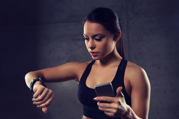 Canvas Print - woman with heart-rate watch and smartphone in gym