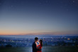 © Parilov - Lovers against the background of a night city, night starry sky and horizon. Concept is a date on the roof, the first love