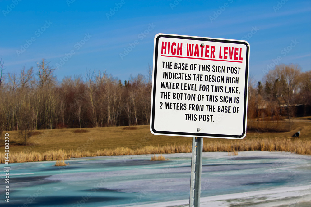 High water level sign along a storm drainage pond Stock Photo | Adobe Stock