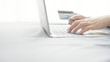 © oatawa - Close up hand using laptop and holding credit card on the bed, Online shopping easy, copy space.