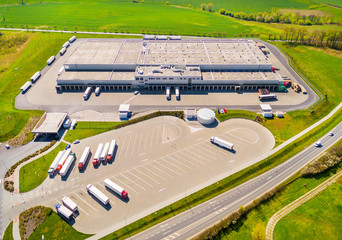 Aerial view of warehouse with trucks. Industrial background. Logistics from above. 