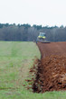 Traktor uprawiający ziemię na polu. 