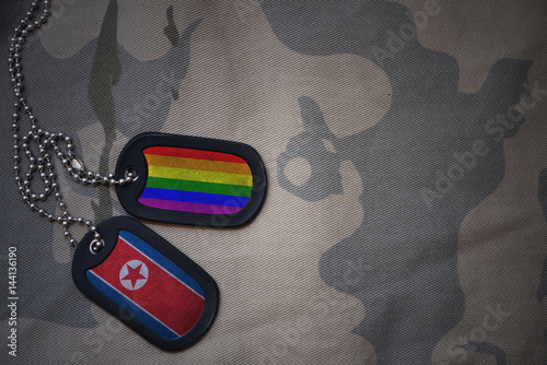 Stampe army blank, dog tag with flag of north korea and gay rainbow flag on the khaki texture background