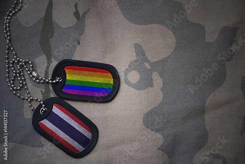 Fotografia army blank, dog tag with flag of thailand and gay rainbow flag on the khaki texture background