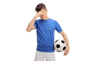 Canvas Print - Upset teenage football player holding his head in disbelief