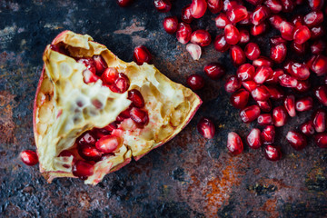 Wall Mural - Pomegranate fruit and seeds over black rustic surface.