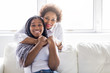 © Louis-Paul Photo - affectionate mother and daughter sitting on sofa