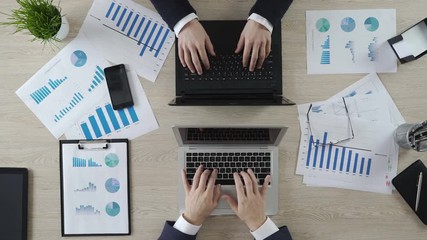 Wall Mural - Hands of business partners typing on laptops opposite each other, negotiations