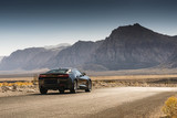 Fototapeta Konie - Black Sports Car on a Desert Road