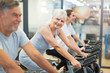 © pikselstock - Confident seniors on exercise bikes in spinning class at gym
