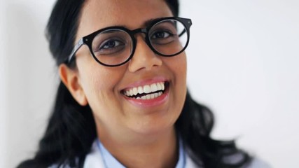 Sticker - face of happy smiling young doctor in glasses