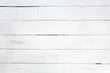 Old wooden planks painted with white paint cracked by a rustic background