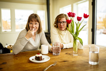 Portrait Of Sisters Sitting At Table