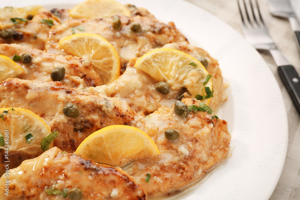 Tasty Italian chicken piccata on plate, closeup