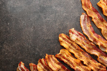 Strips Of Fried Bacon On Gray Background