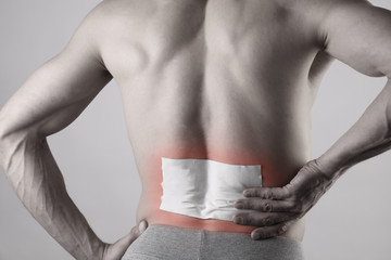 medicated pain relief patch, plaster. man with back pain. pain relief and health care concept isolat