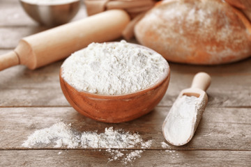 Bowl and scoop full of white flour on grey wooden table