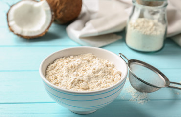 Wall Mural - Bowl with coconut flour on wooden background