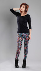 Wall Mural - Woman in Black Top, Colorful Patterned Leggings, and High Heeled Ankle Boots