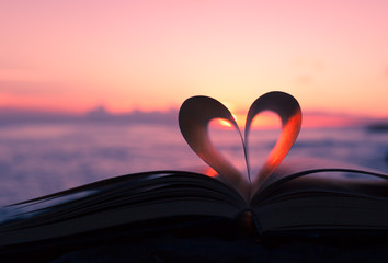 heart from book against a beautiful sunset.