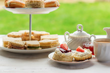 English Afternoon Teas In The Garden Cafe: Scones With Clotted Cream And Jam, Strawberries, With Various Sadwiches On The Background, Selective Focus