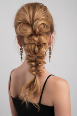 Evening hairstyle. highly collected hair in a braid on blonde girl.