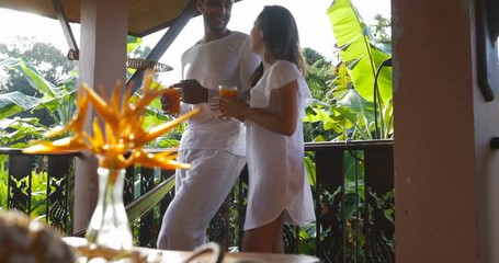 Poster - Couple Hold Juice Glass Talking Standing On Balcony, Man And Woman Morning, Tropical Forest Background Slow Motion 60