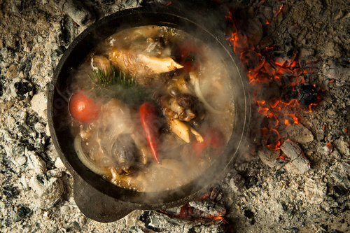 Zdjęcie XXL zupa mięsna z warzywami przygotowywana na palonych węglach. danie jest gotowane i wędzone na węglu drzewnym