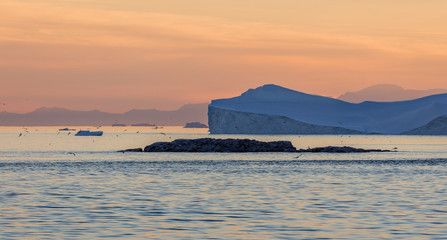 Iceberg in the Disco Bay, Greenland. Their source is by the Jakobshavn glacier. This is a consequence of the phenomenon and catastrophic thawing of ice. Ilulissat on background