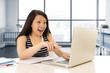 © Wordley Calvo Stock - happy chinese asian woman working and studying on her computer sitting at modern office desk smiling cheerful