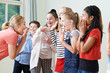 Group Of Children With Teacher Enjoying Drama Class Together