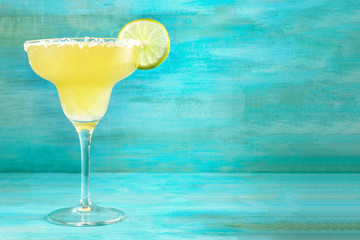 Wall Mural - Lemon Margarita cocktails on vibrant turquoise with copyspace