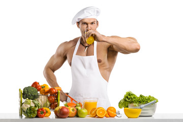 Wall Mural - Man bodybuilder cook, cooking freshly squeezed juice and vegetables salad