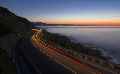 Car lights on the road at night by the sea, Gipuzkoa