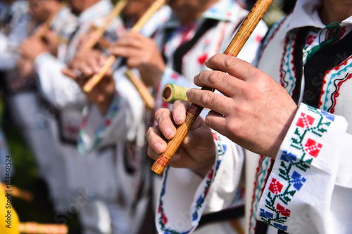 Plakat Ludzie śpiewają na tradycyjnych drewnianych fletach