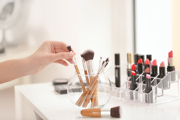 Poster - Professional makeup artist taking brush at beauty salon