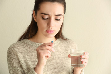 Poster - Beautiful young woman taking pill at home