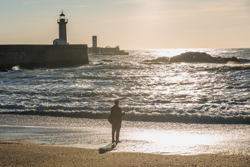 Canvas Print - Man catches fishes on the beach in Porto city, Portugal