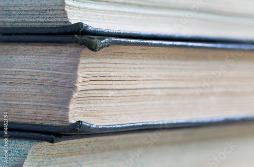Fotografia, Obraz Close up of the corner of stacked books leading away to the right with shallow d