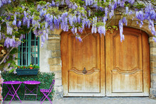 Colorful Purple Tables Of Outdoor Parisian Cafe And Wisteria In Full Bloom