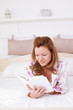 © Svetlana - Beautiful woman reading a book in bed.