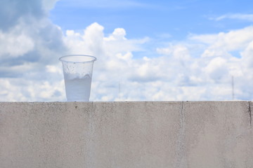 ice in glass-plastic on the floor with blue sky  background