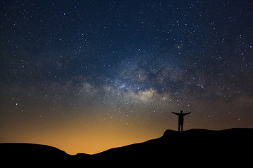 Wall Mural - landscape with milky way, night sky with stars and silhouette of happy people standing on the mounta