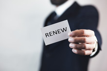 Businessman Holding A Card With Text Renew